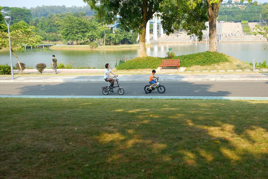 公园湖边骑自行车的母子