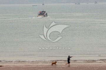 海滩上遛狗的人