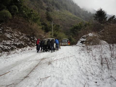 汽车 陷雪地 众人 推