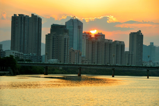 夕阳溪边城市高楼大厦