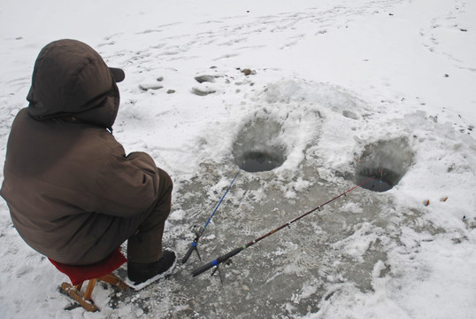 冰天雪地钓鱼的老人