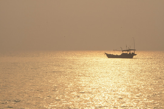 金色海面上的渔船