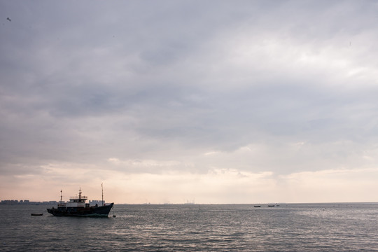 海面上行驶的渔船 天空 浓云