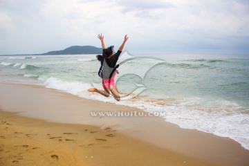 海滩跳跃的少女