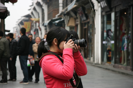 在河坊古街旅行拍摄照片的女孩