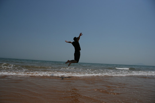 海边跳跃欢呼旅行的人
