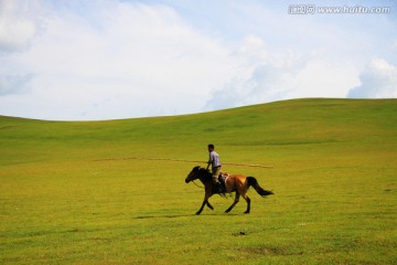 草原上骑马奔跑的蒙古人
