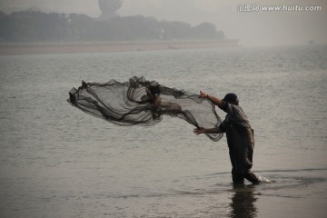 长沙湘江风光带打鱼的渔夫撒网