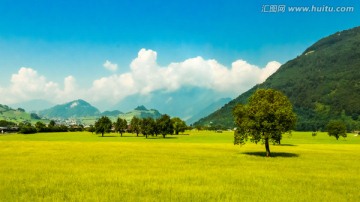 蓝天白云丘壑绿地的瑞士风景