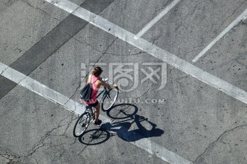 俯拍马路上骑自行车的女人