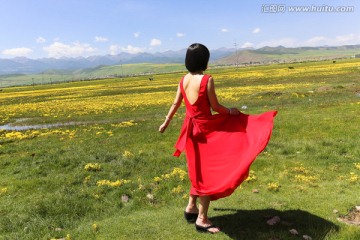 田野里穿红裙子的女人背影