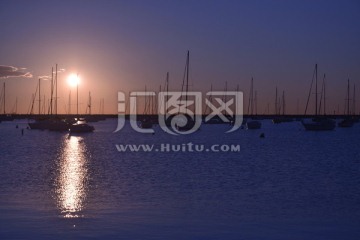 太阳初升时的水中帆船