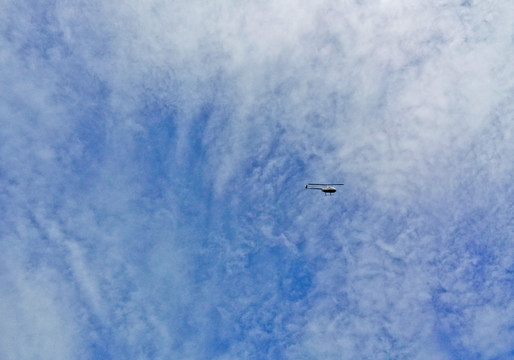 蓝天白云间的直升飞机