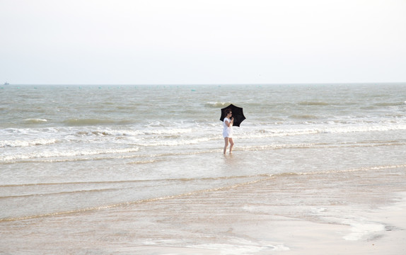 海水中打伞的游人