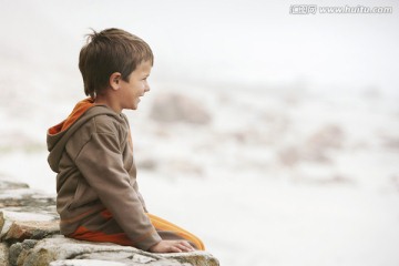 男孩坐着看海