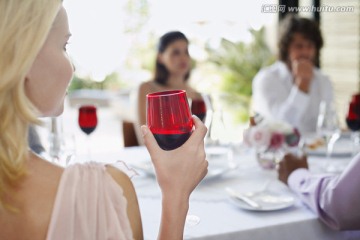 年轻的女人拿着酒杯