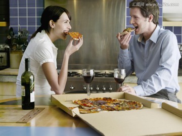 小情侣在厨房吃比萨饼