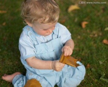 宝宝玩着秋天的树叶