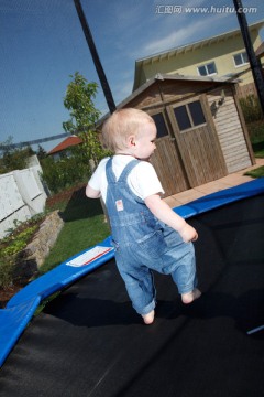 小男孩在花园里跳蹦床