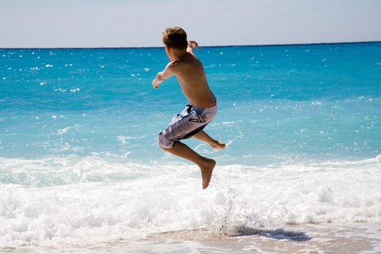 海边跳跃的小男孩
