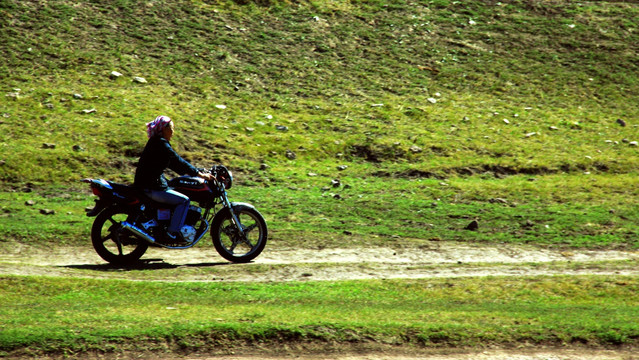 草原上骑摩托车的鄂温克族女人