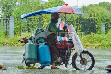 雨中送煤气罐的摩托车