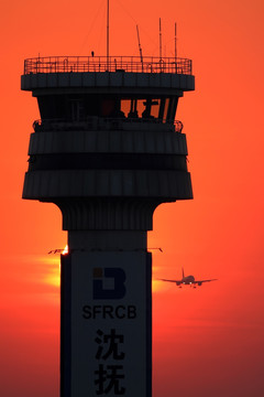 夕阳中塔台和降落的飞机