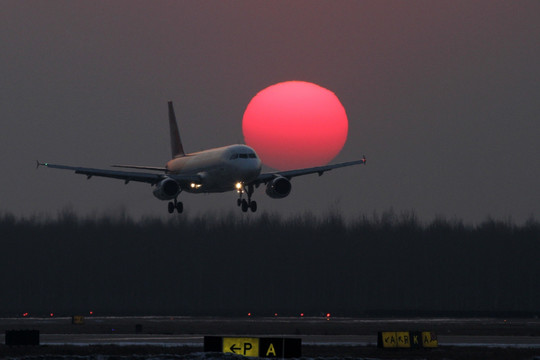 夕阳中降落的飞机