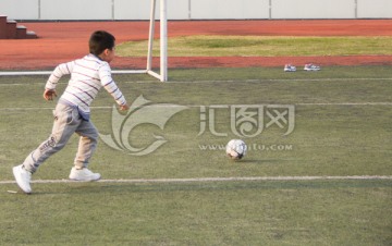 小男孩追足球射门