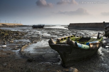 遗弃在滩涂上的腐朽木船