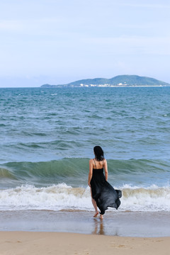 三亚海边穿黑色长裙的女人背影