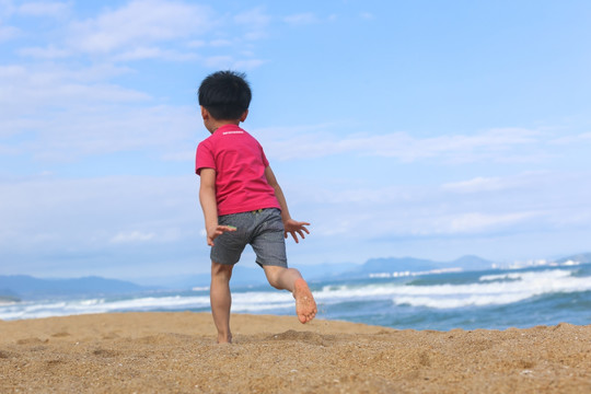 沙滩上玩耍的小孩背影