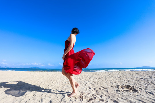 三亚沙滩穿红裙子的女人背影