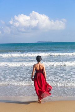 三亚沙滩穿红裙子的女人背影