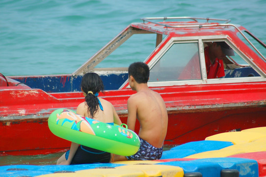 游泳后再浮筒上休息的青年男女