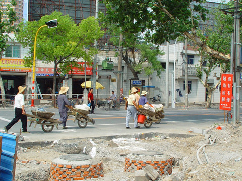 走在城市道路上的一队鸡公车