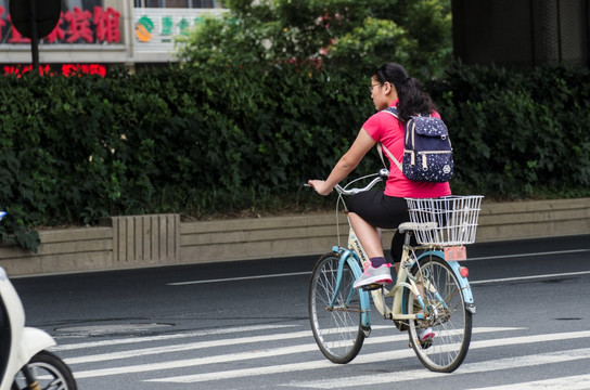 骑自行车过马路的女孩
