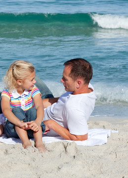 父亲和小女儿在海边聊天