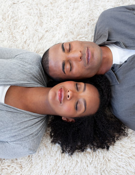 微笑的黑人夫妇躺在地板上