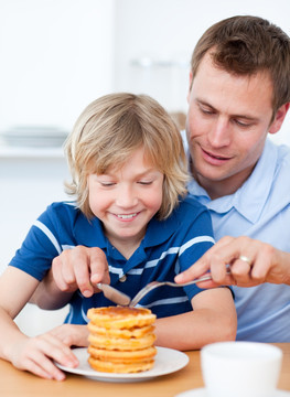 父亲和儿子一起吃蜂蜜松饼