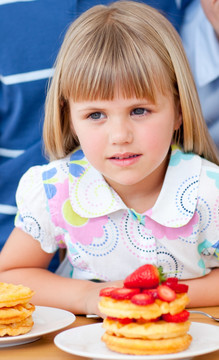 可爱的小女孩吃草莓松饼