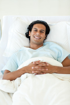 微笑的男病人躺在病床上