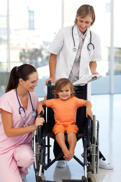 医护人员推着轮椅上的小孩