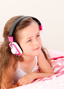 在床上听音乐的小女孩