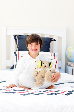 微笑的小男孩抱着玩具熊