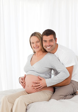 丈夫和怀孕的妻子幸福的微笑