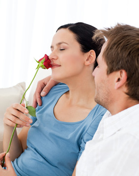 沙发上拿着玫瑰花的夫妻