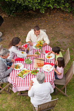 家庭在花园外面吃饭