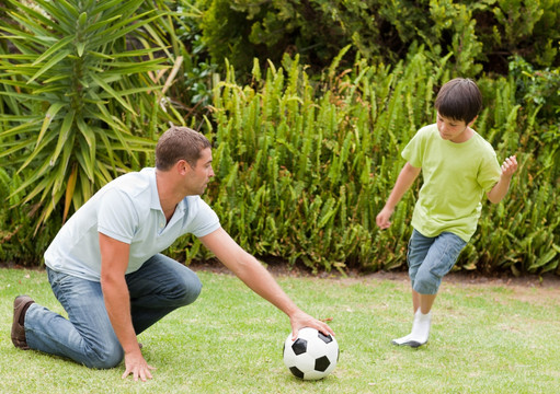 儿子和父亲一起踢足球