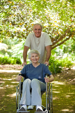 推着轮椅上的妻子散步的老人